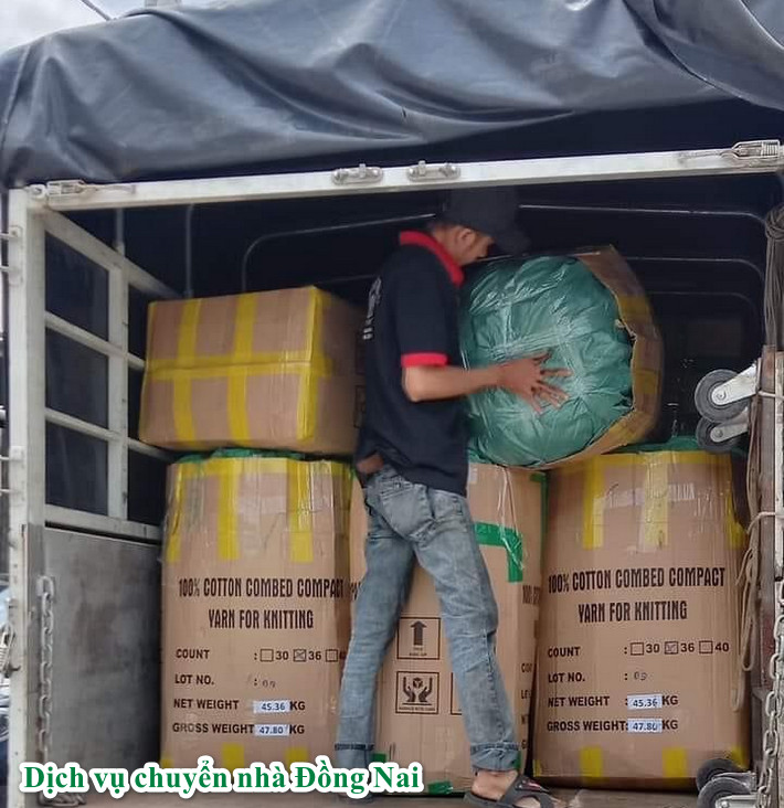 một người đang chuyển thùng đồ trên xe tải xuống